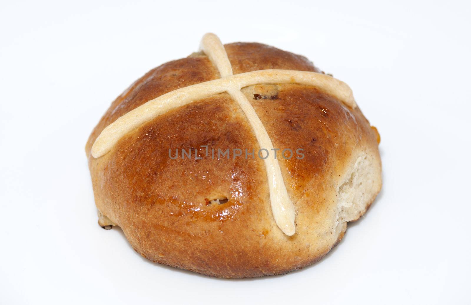 Cross bun with raisins and dried apricots isolated on white