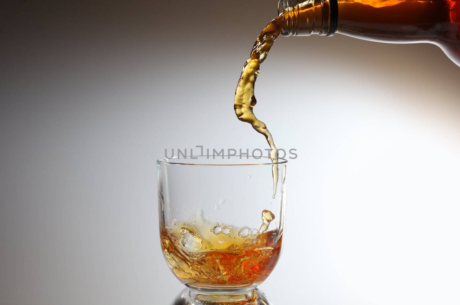 whiskey being poured into a glass by rudchenko