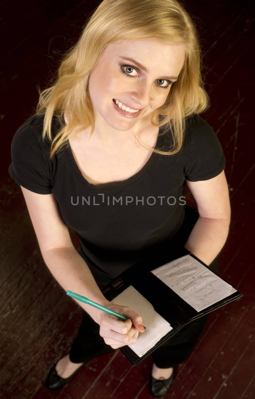 Young Attractive Female Server Writes Order in the Restaurant