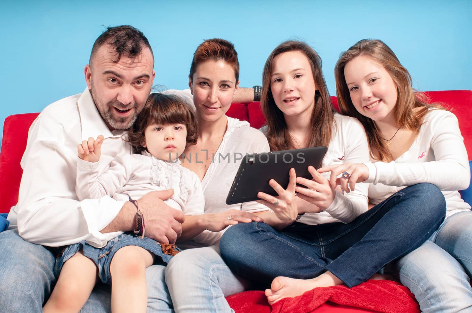 happy family on the couch using tablet in the living room