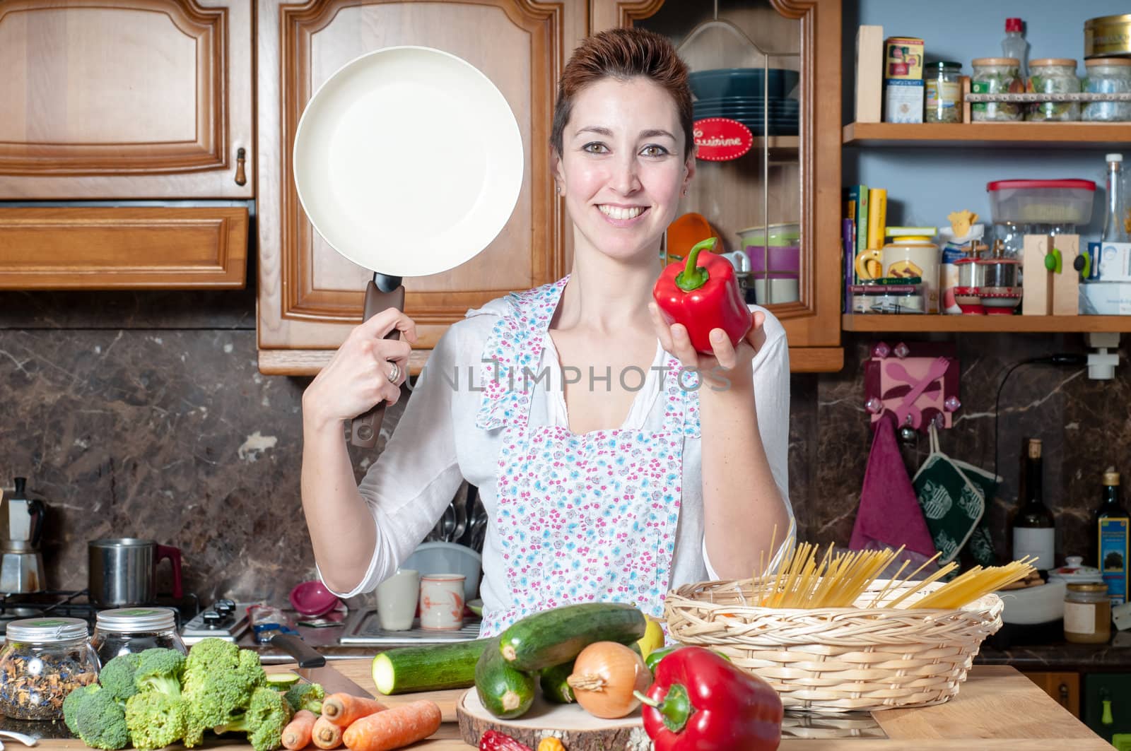 beautiful housewife cooking vegetables in the kitchen