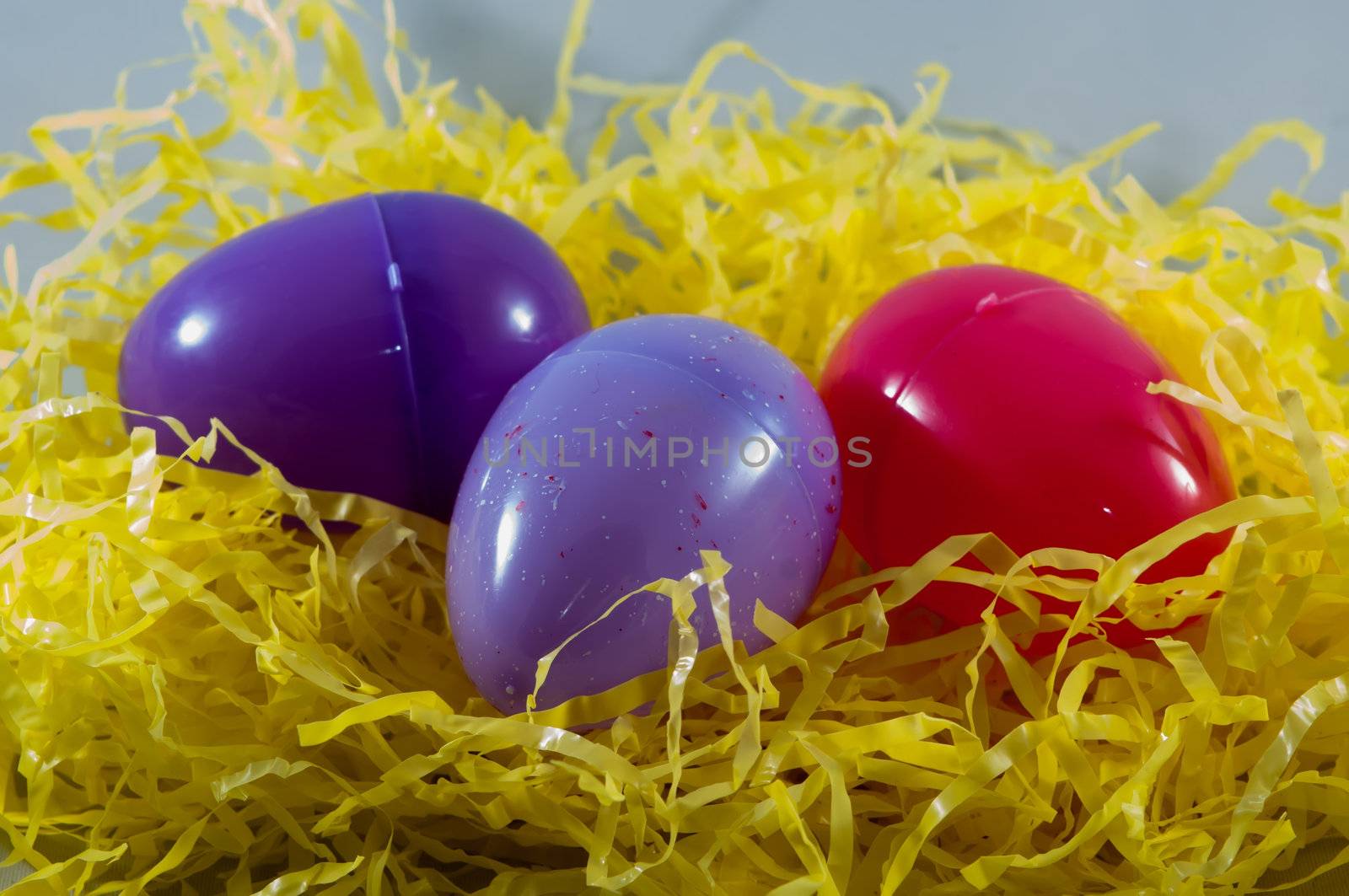 colorful plastic easter eggs in fake hay