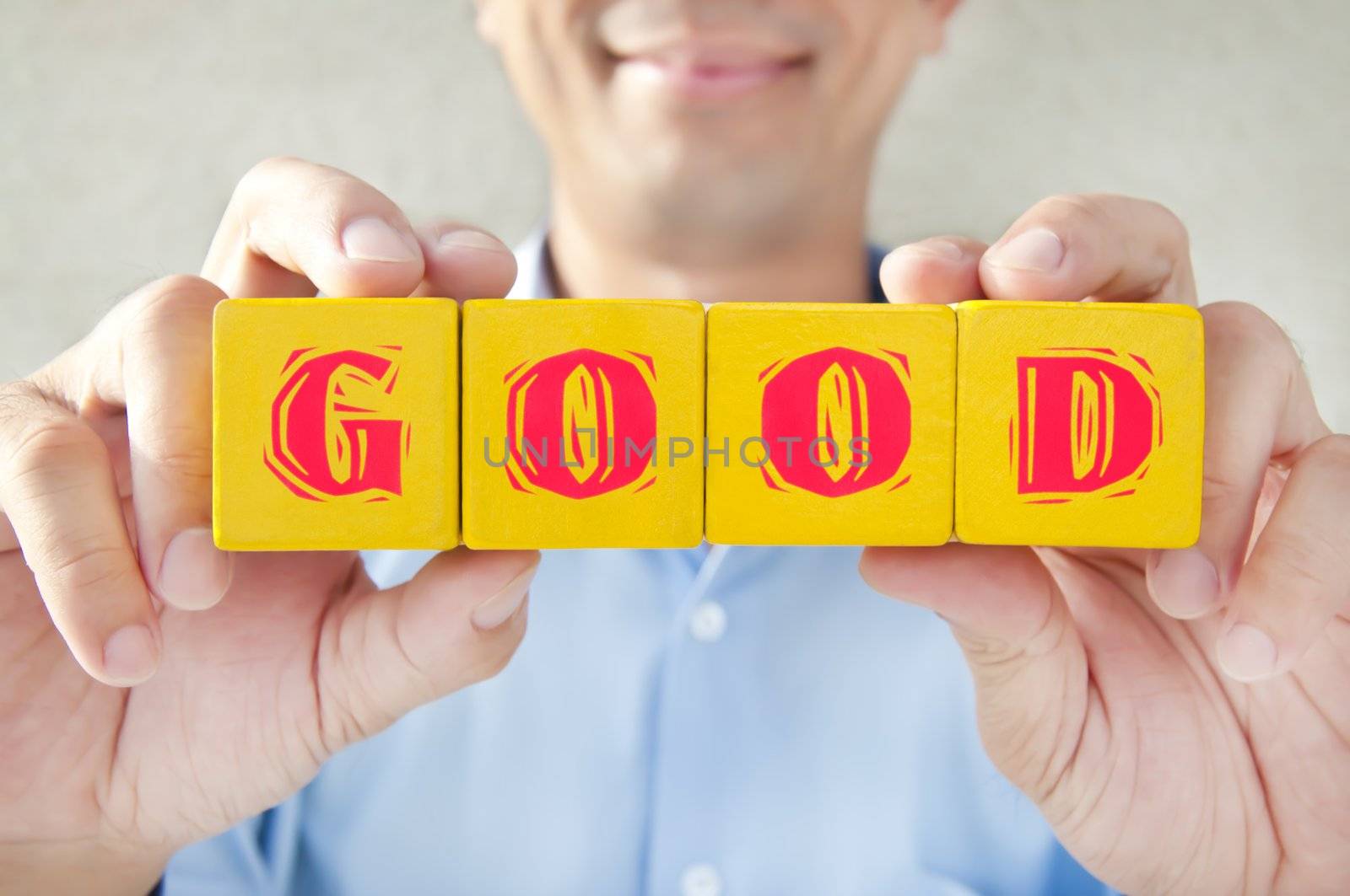 Salesman very happy to hold a good building blocks to express the meaning of good
