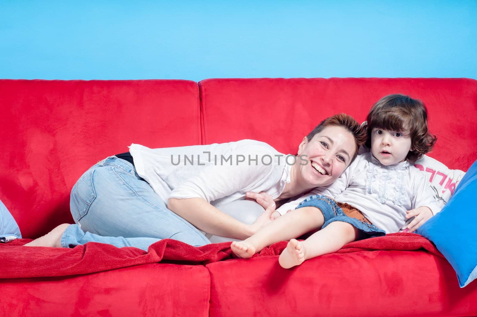 mother and little daughter hugging on the couch by peus