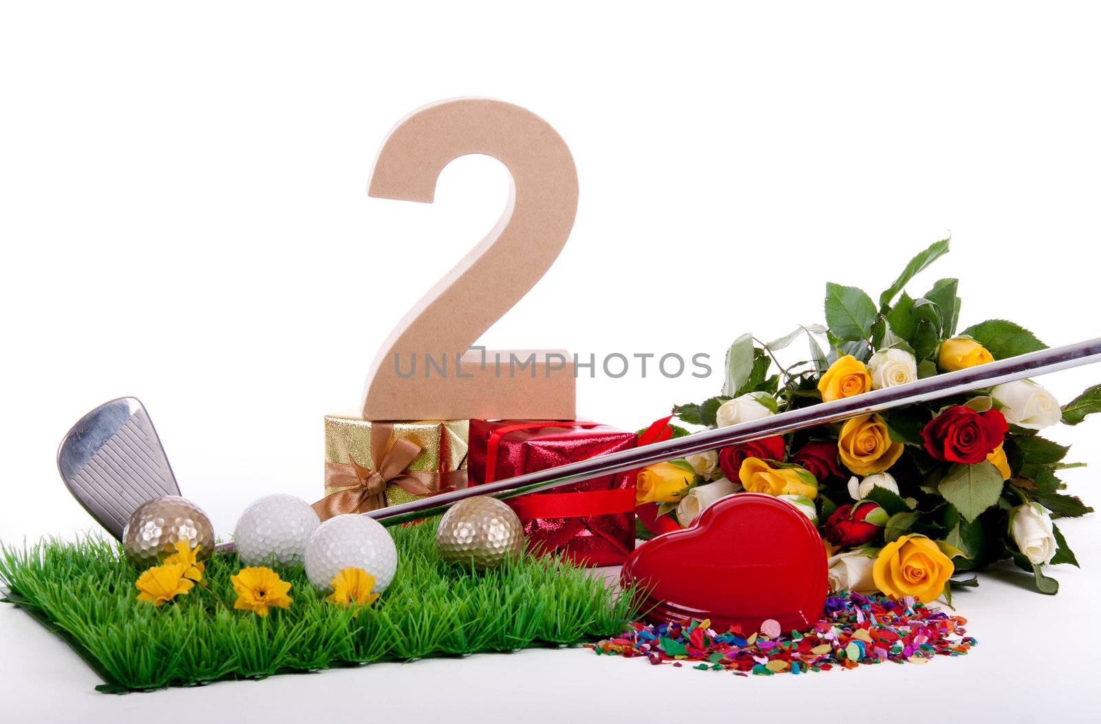 Roses, a golf club and golf balls on an artificial peace of grass to be used as a birthday card