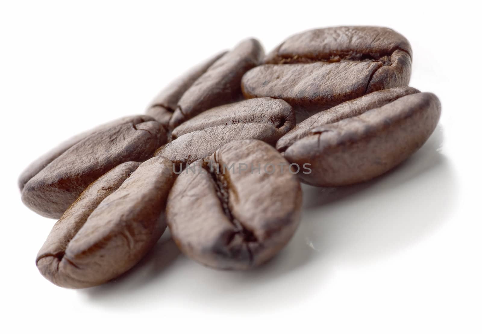 Seven coffee beans on the white background. Flower made of coffee beans. Soft focus.