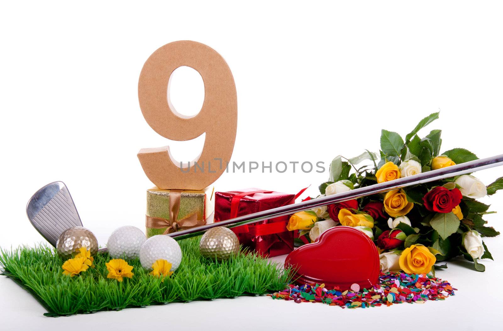 Roses, a golf club and golf balls on an artificial peace of grass to be used as a birthday card