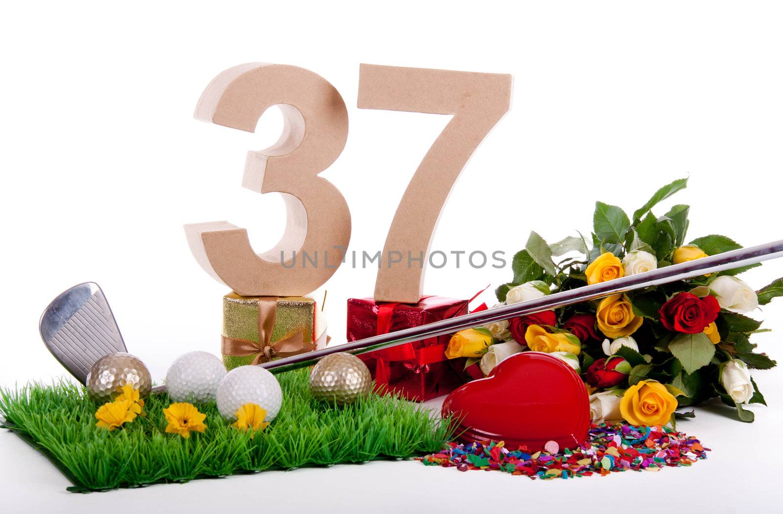 Roses, a golf club and golf balls on an artificial peace of grass to be used as a birthday card