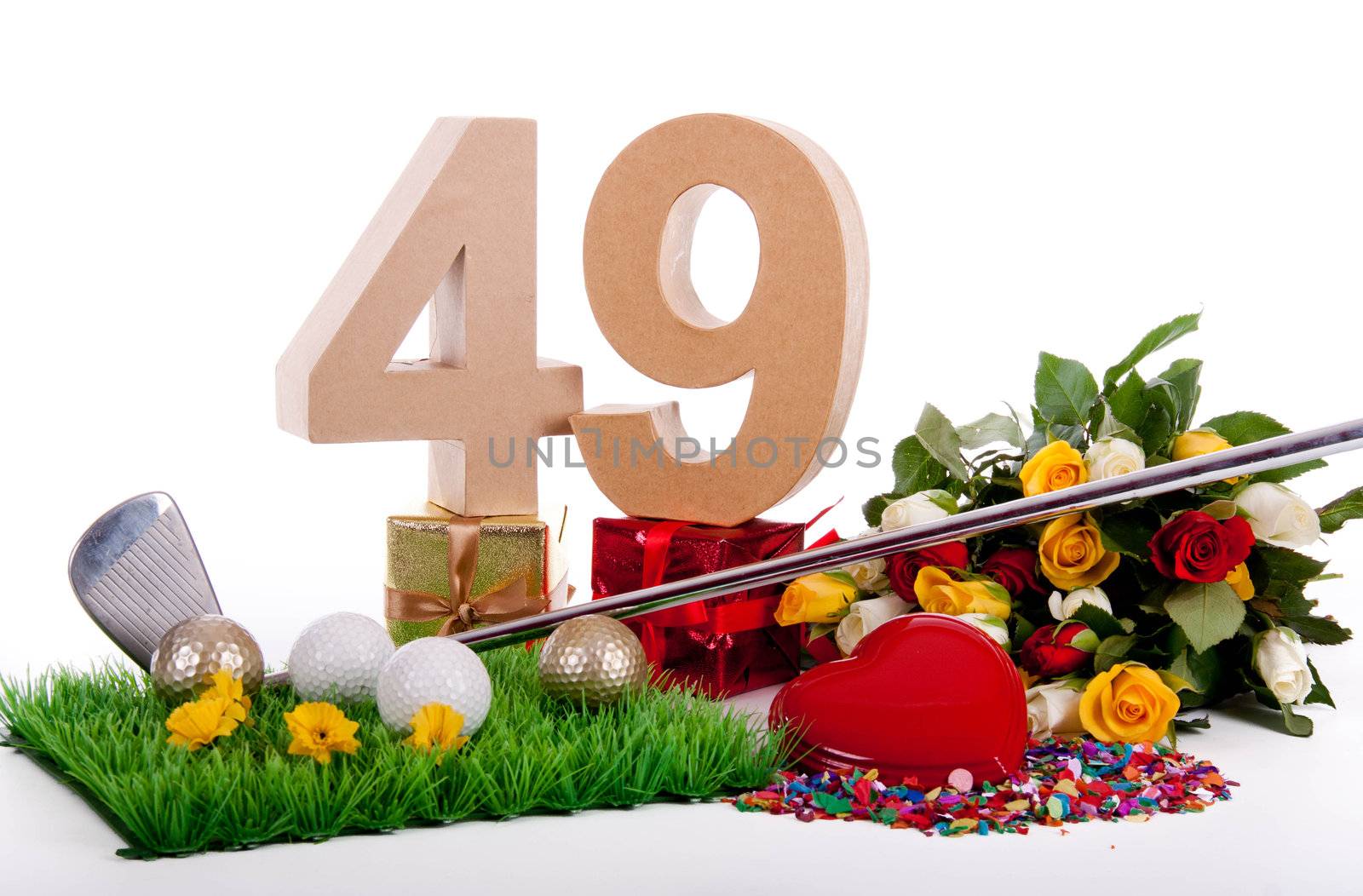 Roses, a golf club and golf balls on an artificial peace of grass to be used as a birthday card