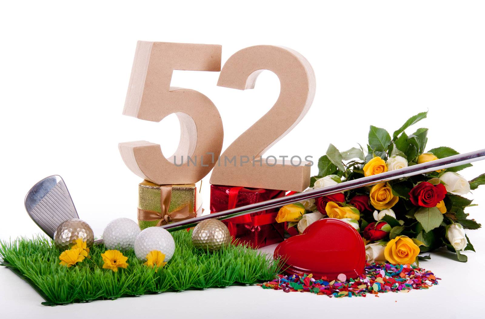 Roses, a golf club and golf balls on an artificial peace of grass to be used as a birthday card