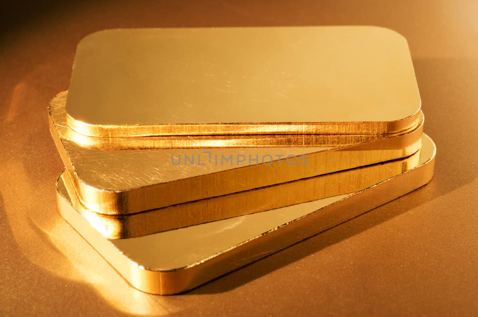 three gold ingots on a golden background. shallow depth of field.