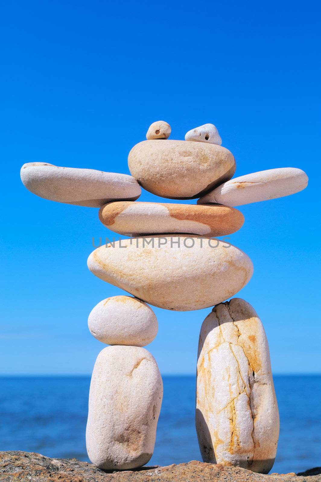 Symbolic figurine is made of pebbles on the shore