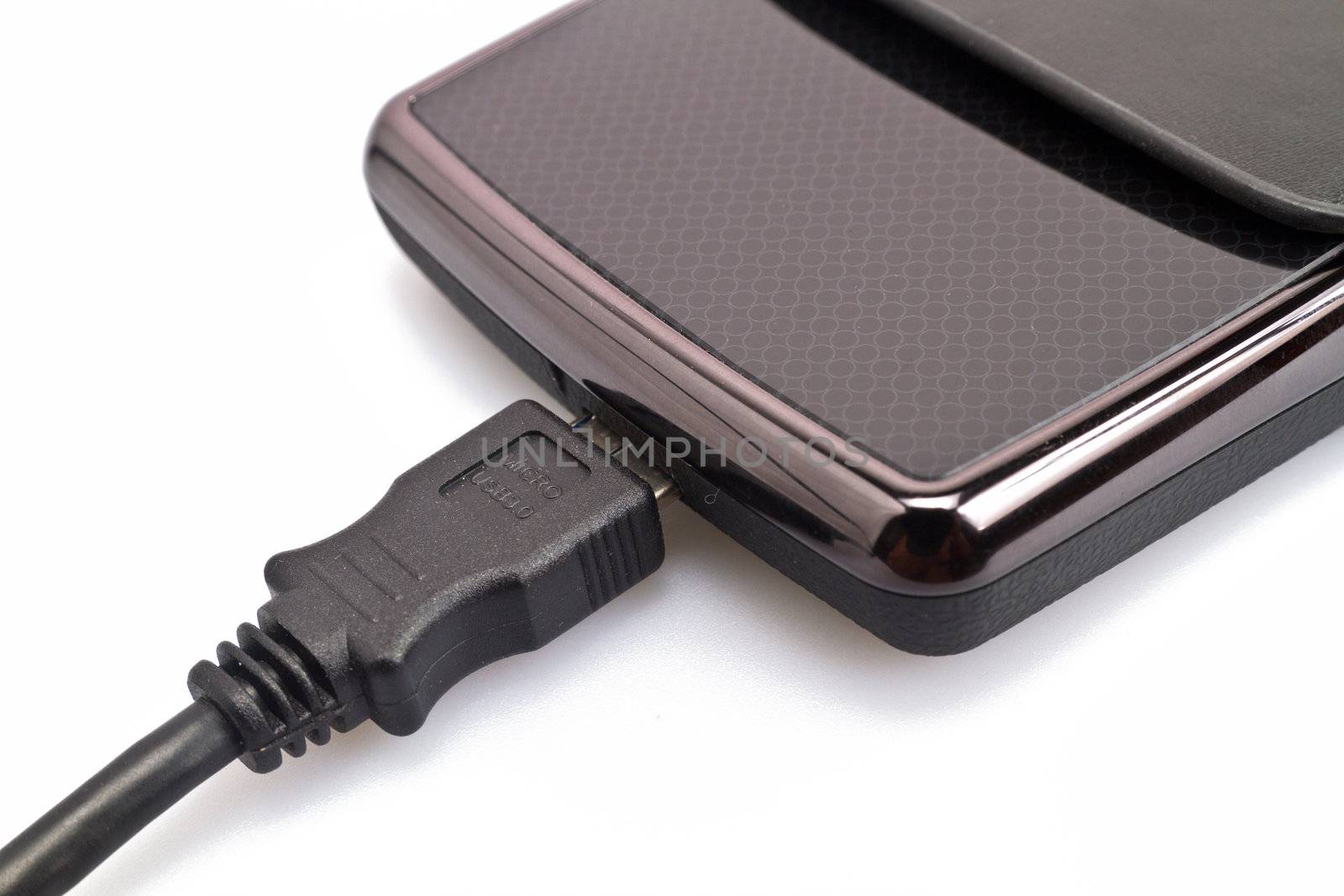 close up view of a portable harddisk in  soft leather case and USB cable on white background