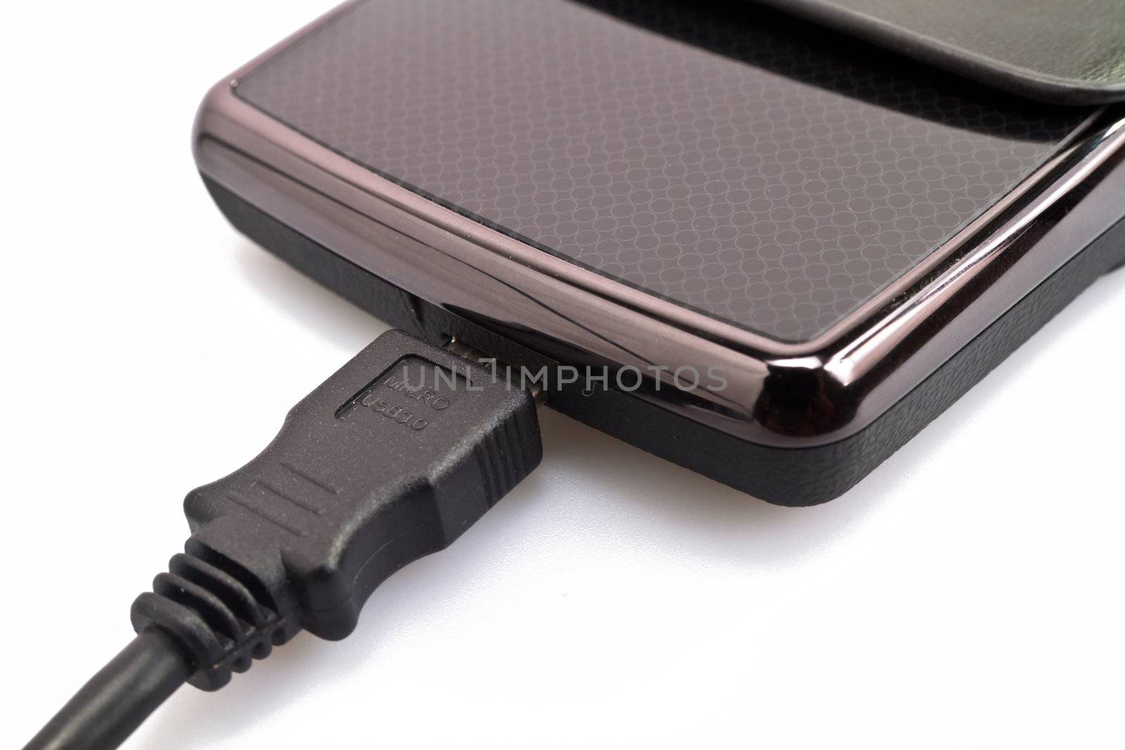 close up view of a portable harddisk in  soft leather case and USB cable on white background