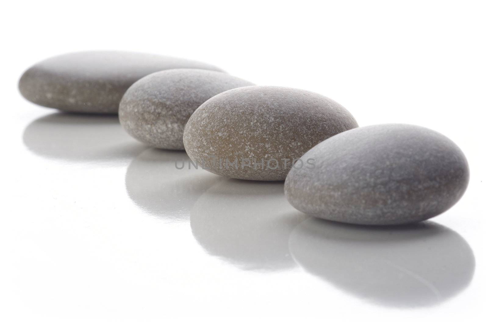 Four stones arranged in a straight line white background.