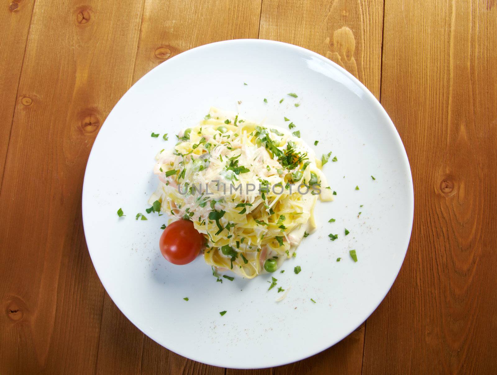 pasta Fettuccine Alfredo with cherry tomato, ham. close-up