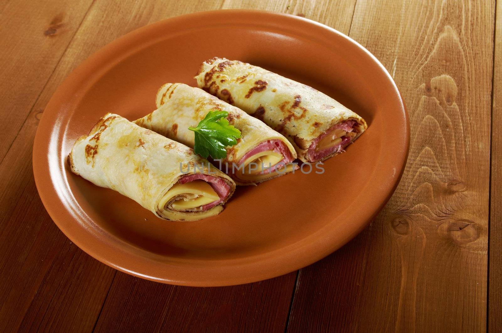 rolled pancakes stuffed ham and cheese. Shallow depth-of-field.