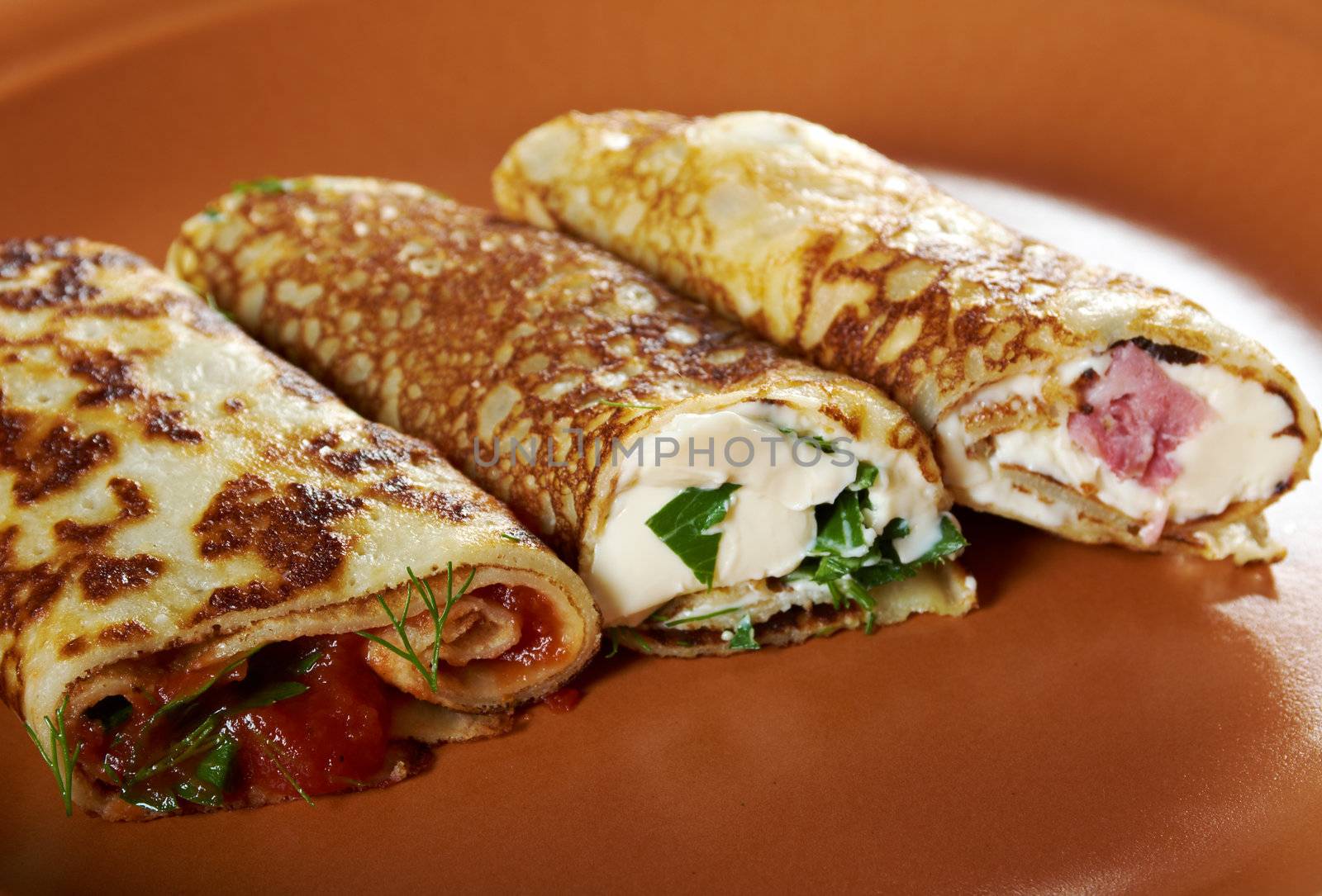 rolled pancakes stuffed ham and cheese. Shallow depth-of-field.