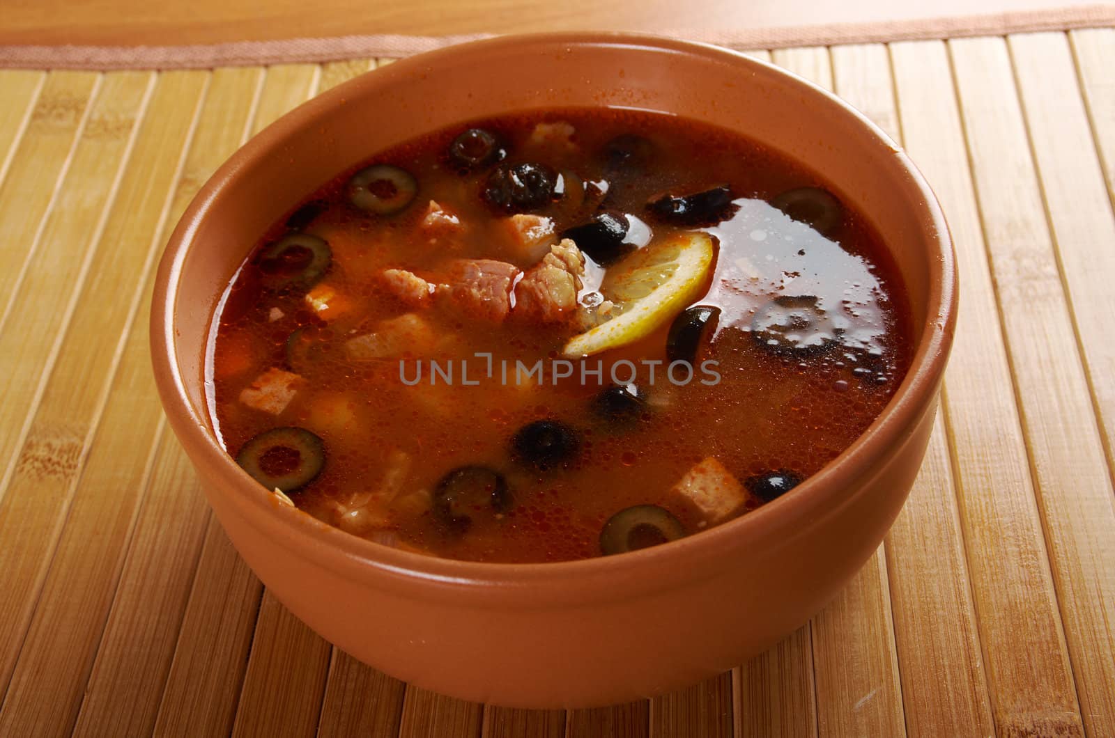 Solyanka on the plate.Solyanka, Russian soup with beef,sausage,chicken and lemon, olives