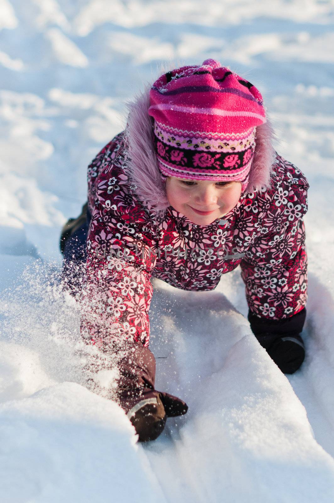 Baby crawls all fours on snow and smile