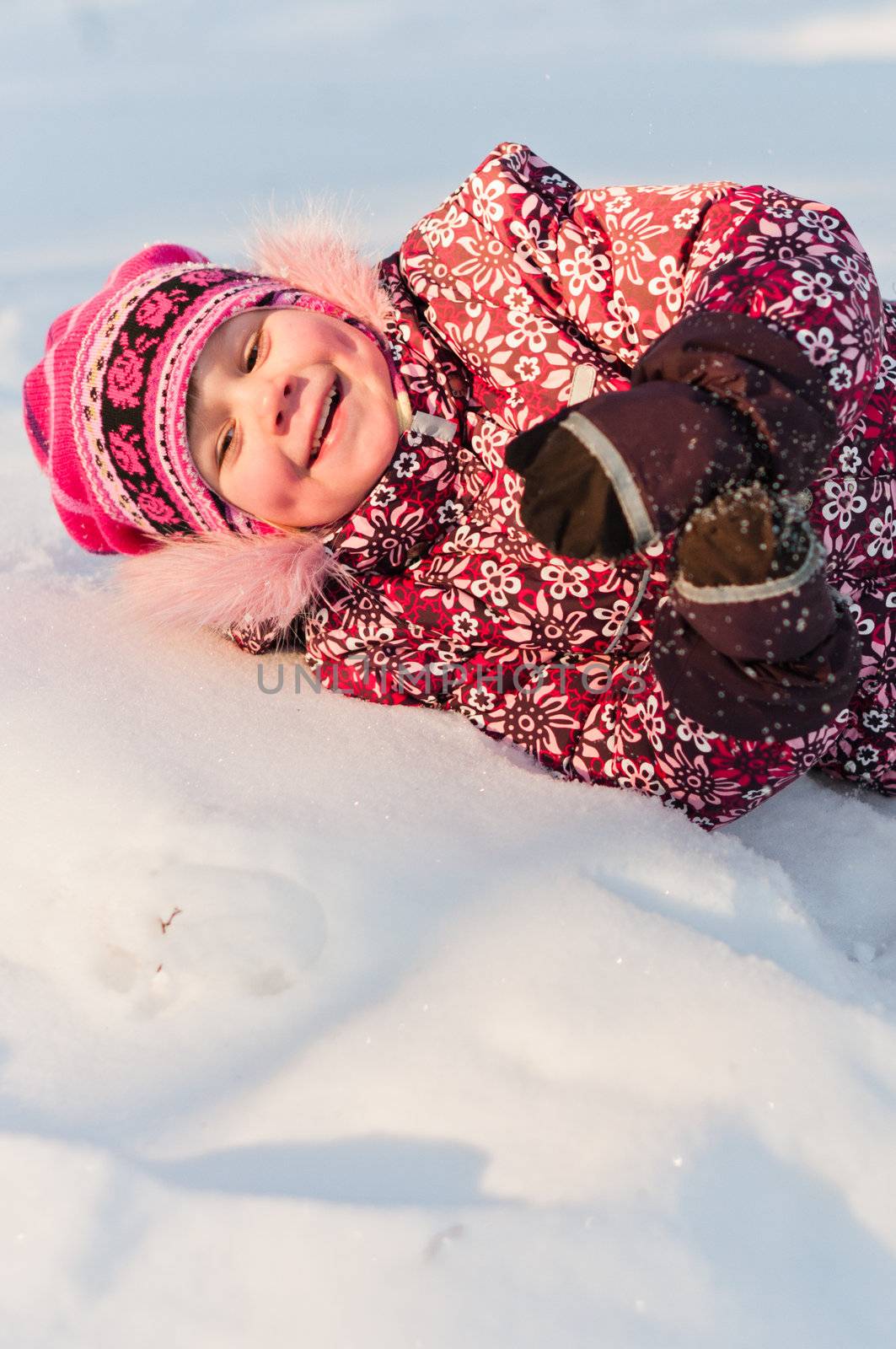 Baby lays on snow and laugh by dmitryelagin