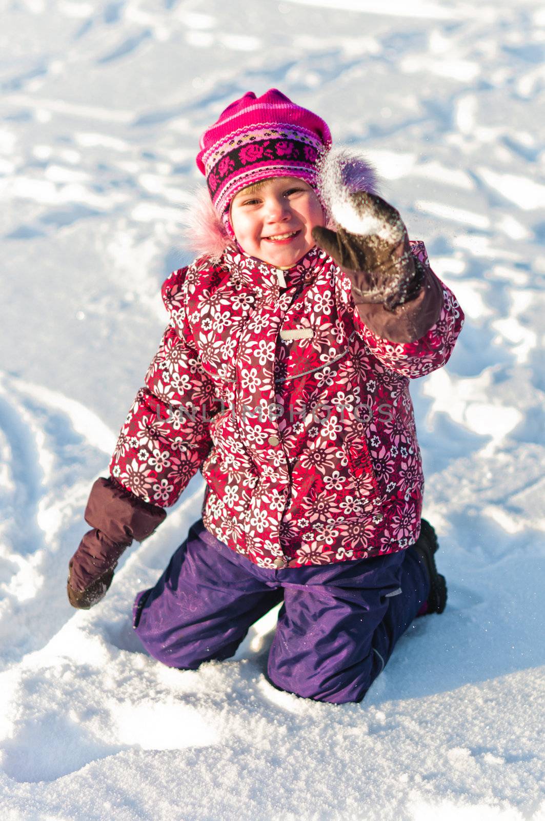 Baby sits on snow and smile by dmitryelagin