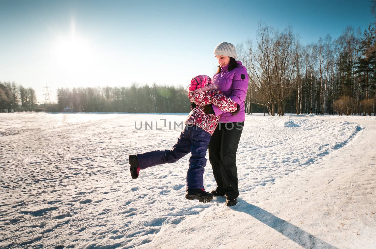 Mother plays with little daughter in wood and smile