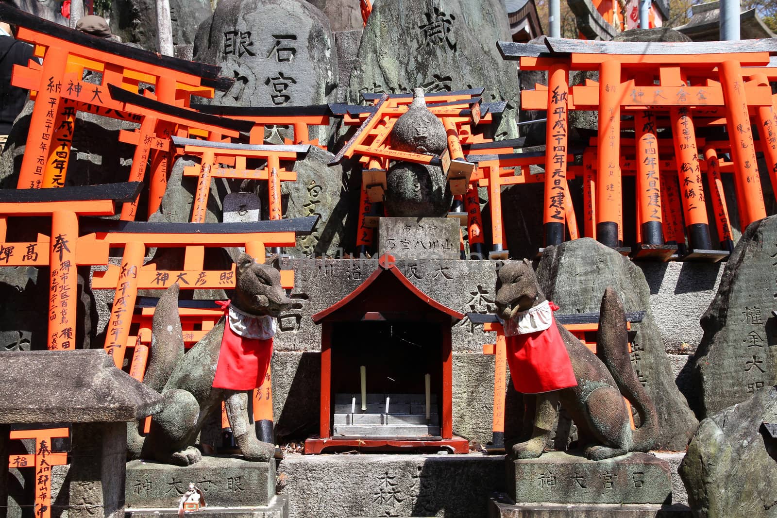 Fushimi Inari Taisha shrine in Kyoto prefecture of Japan. Famous shinto shrine. Statues of fox messengers (kitsune).