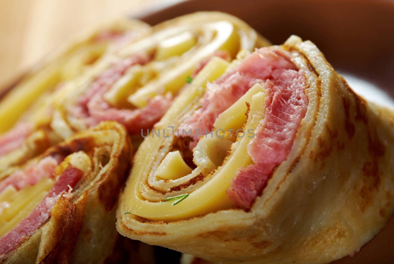 rolled pancakes stuffed ham and cheese. Shallow depth-of-field.