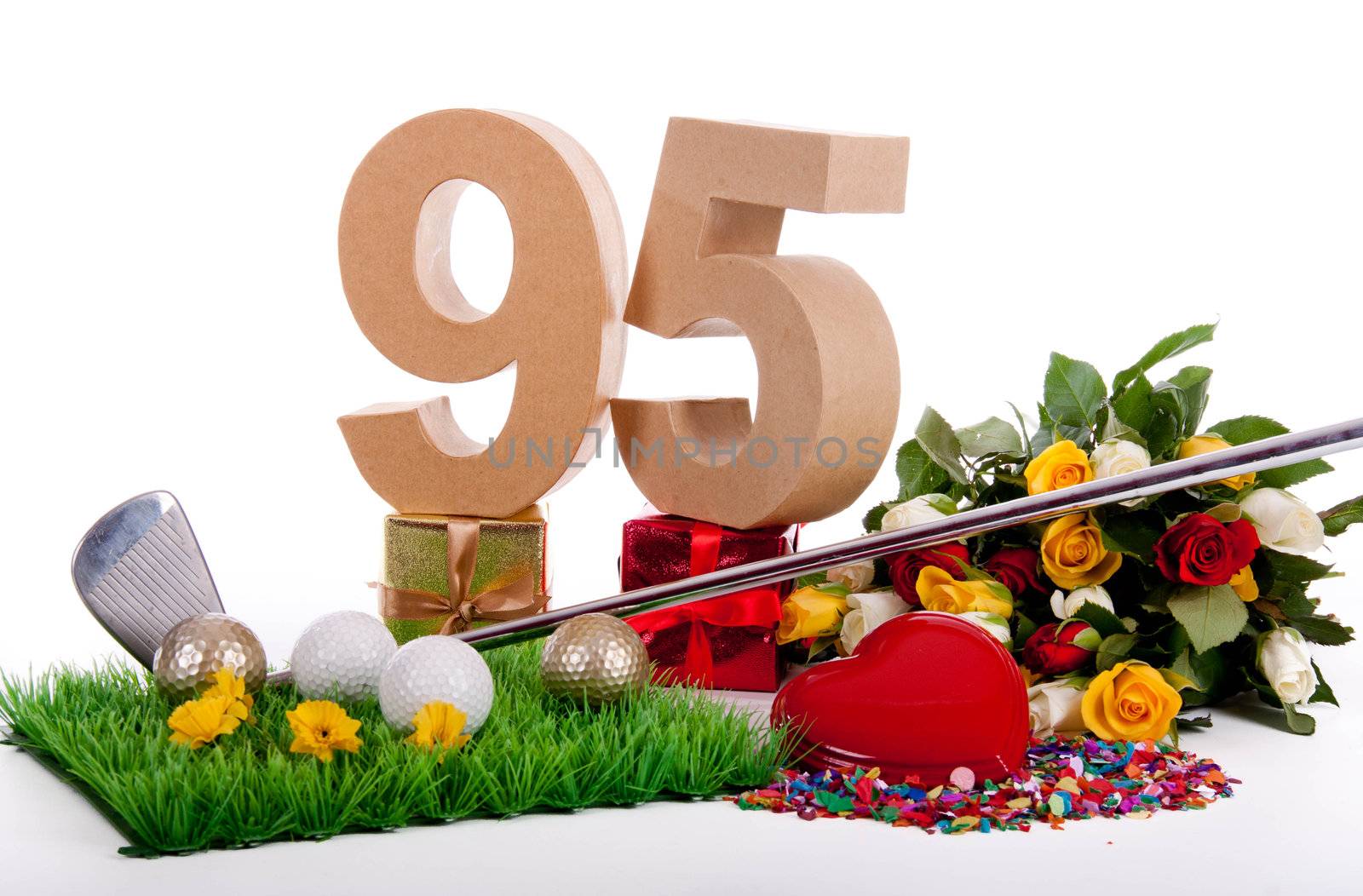 Roses, a golf club and golf balls on an artificial peace of grass to be used as a birthday card