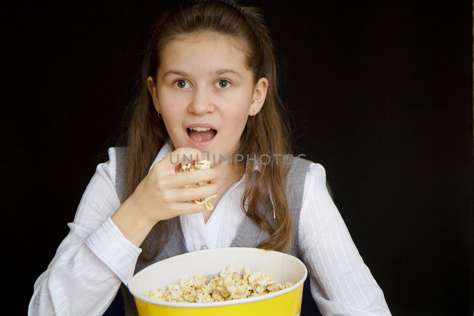 emotional girl with popcorn on a black background