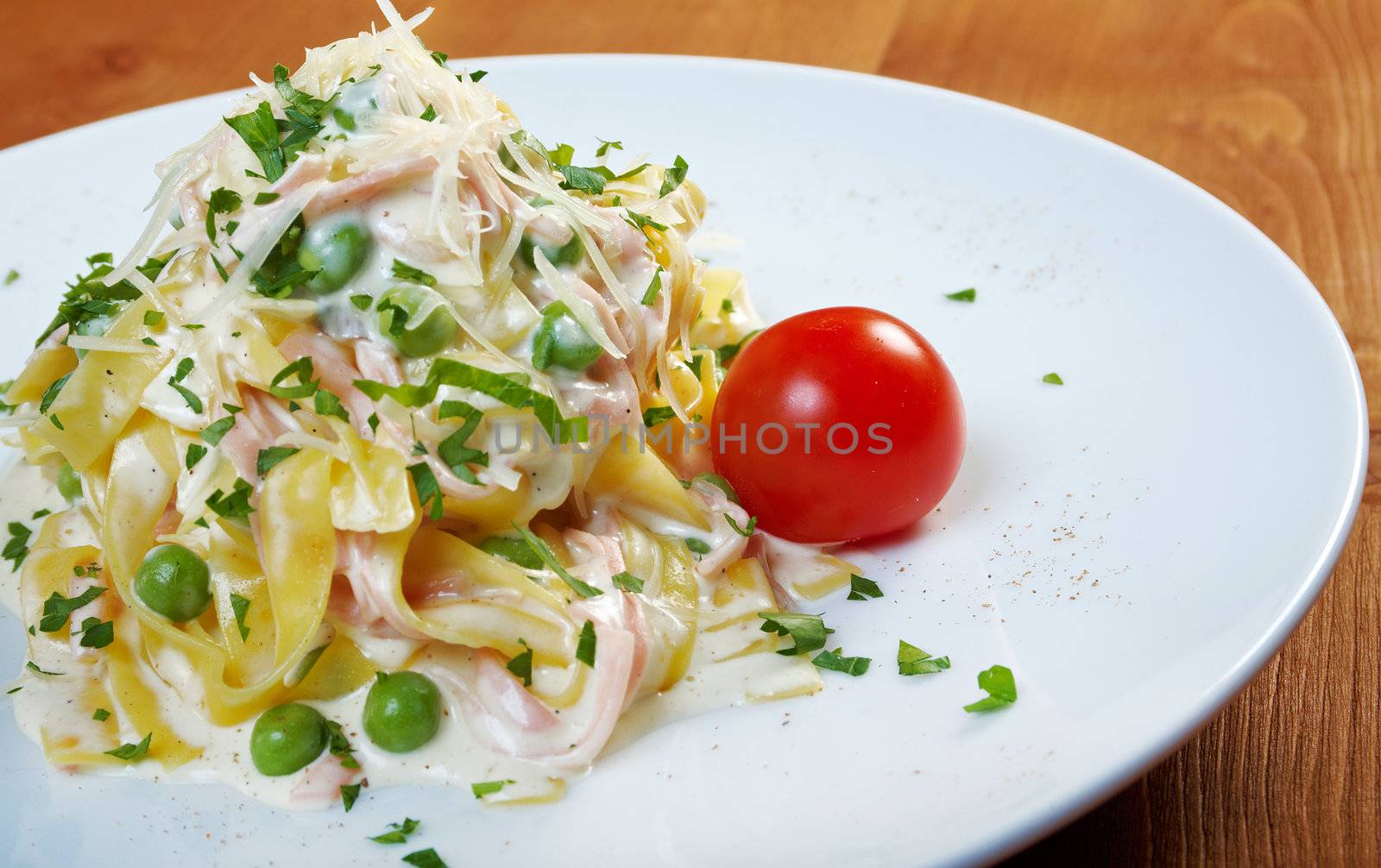 pasta Fettuccine Alfredo with cherry tomato, ham. close-up