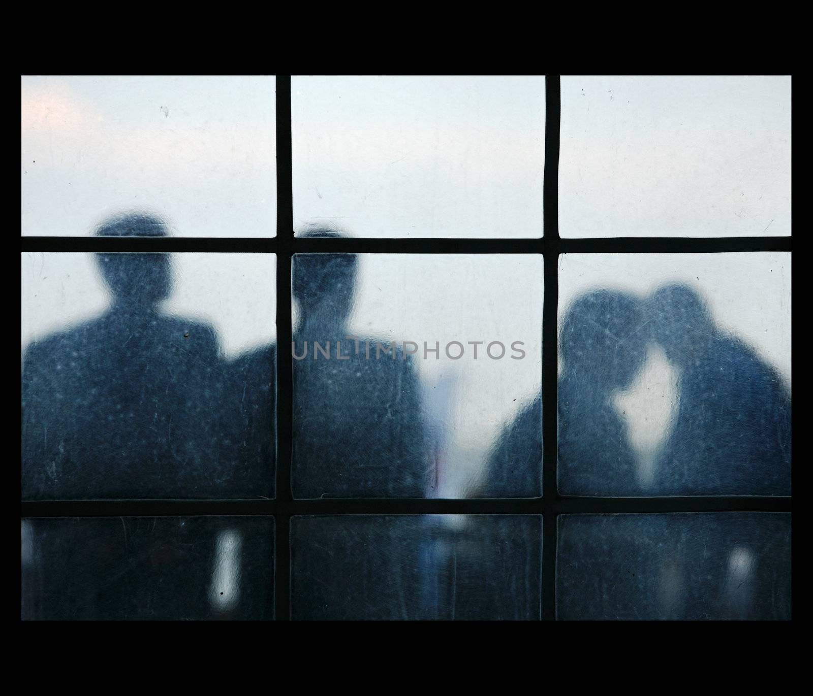 Four silhouettes of people behind of a window