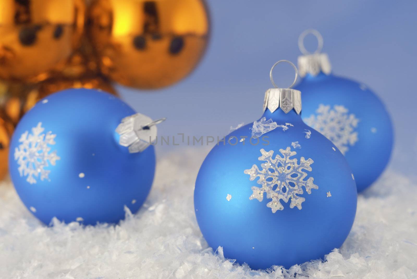 Three Christmas decorations lay in the snow