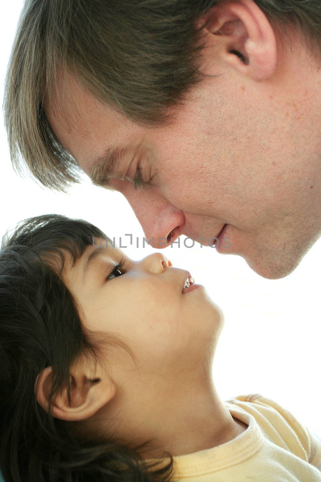 Loving father face to face with his toddler son.