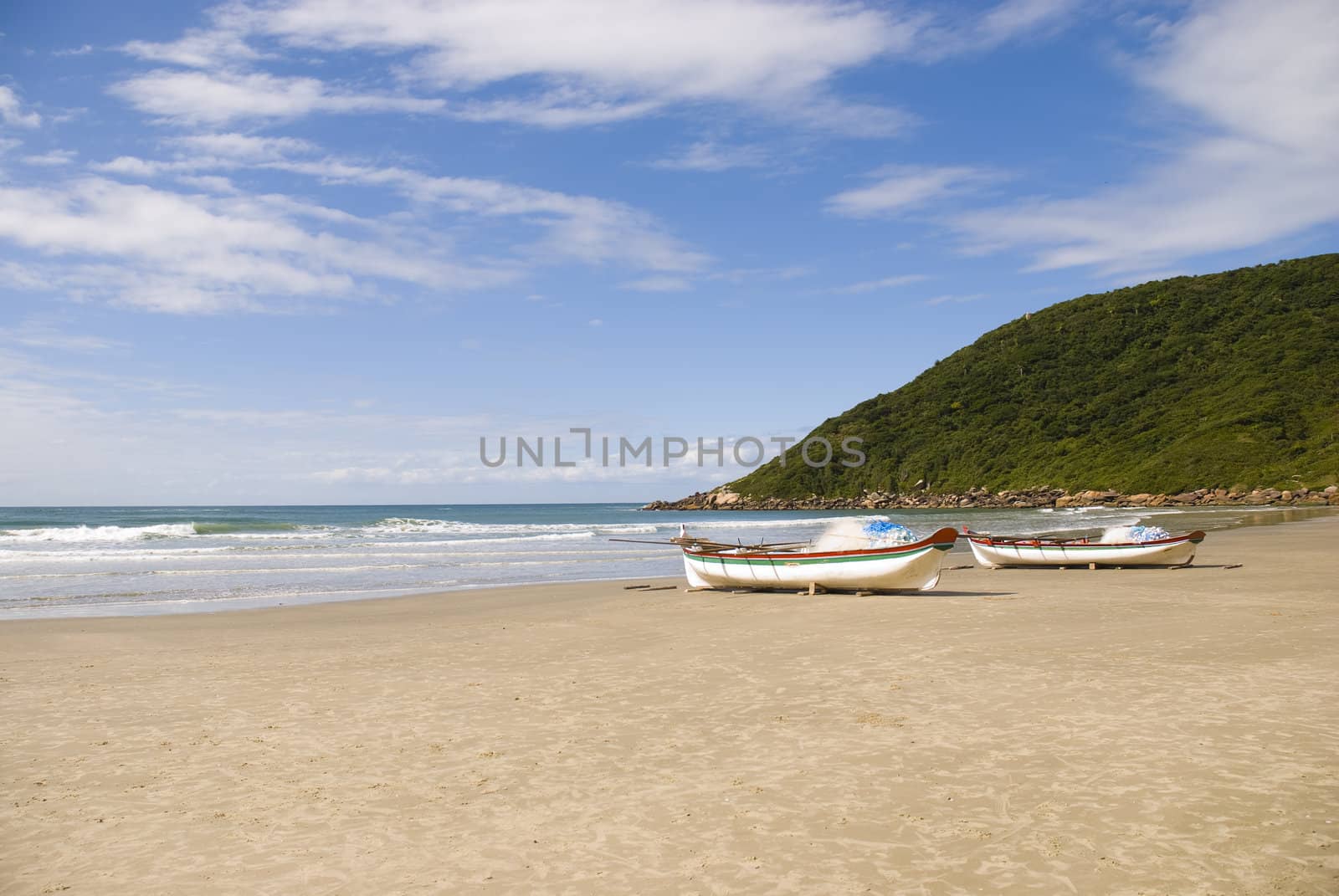 Deserted beach with empty fishing boats in the sand.