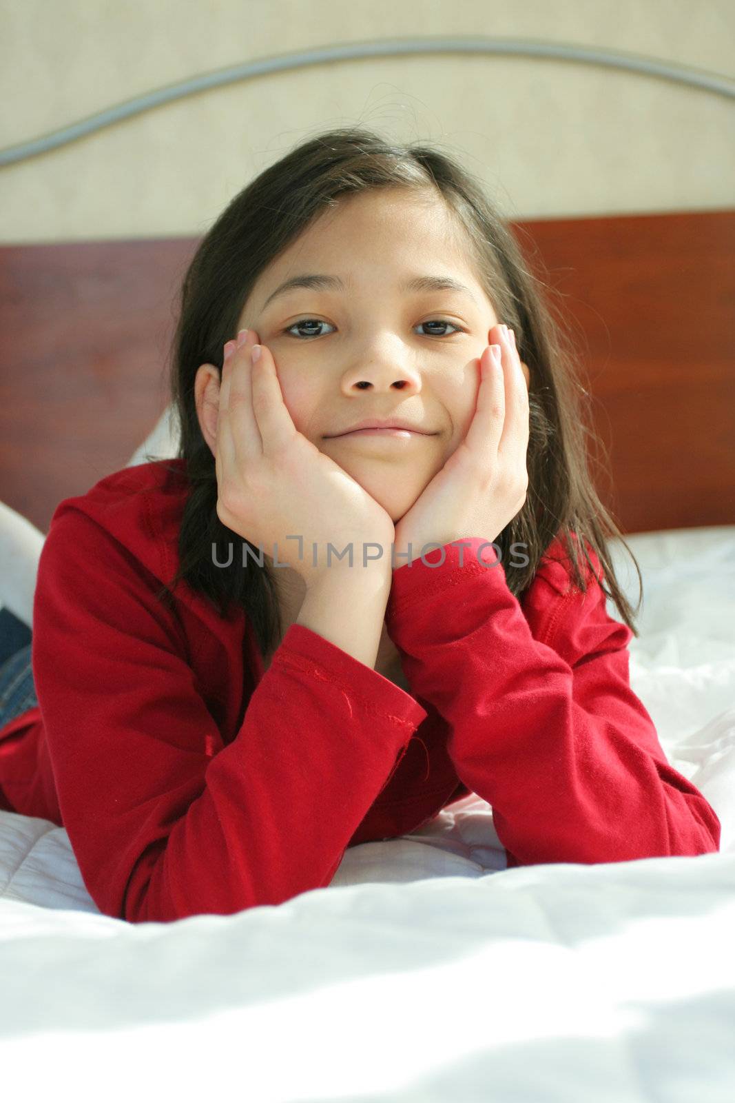 Child lying on bed thinking