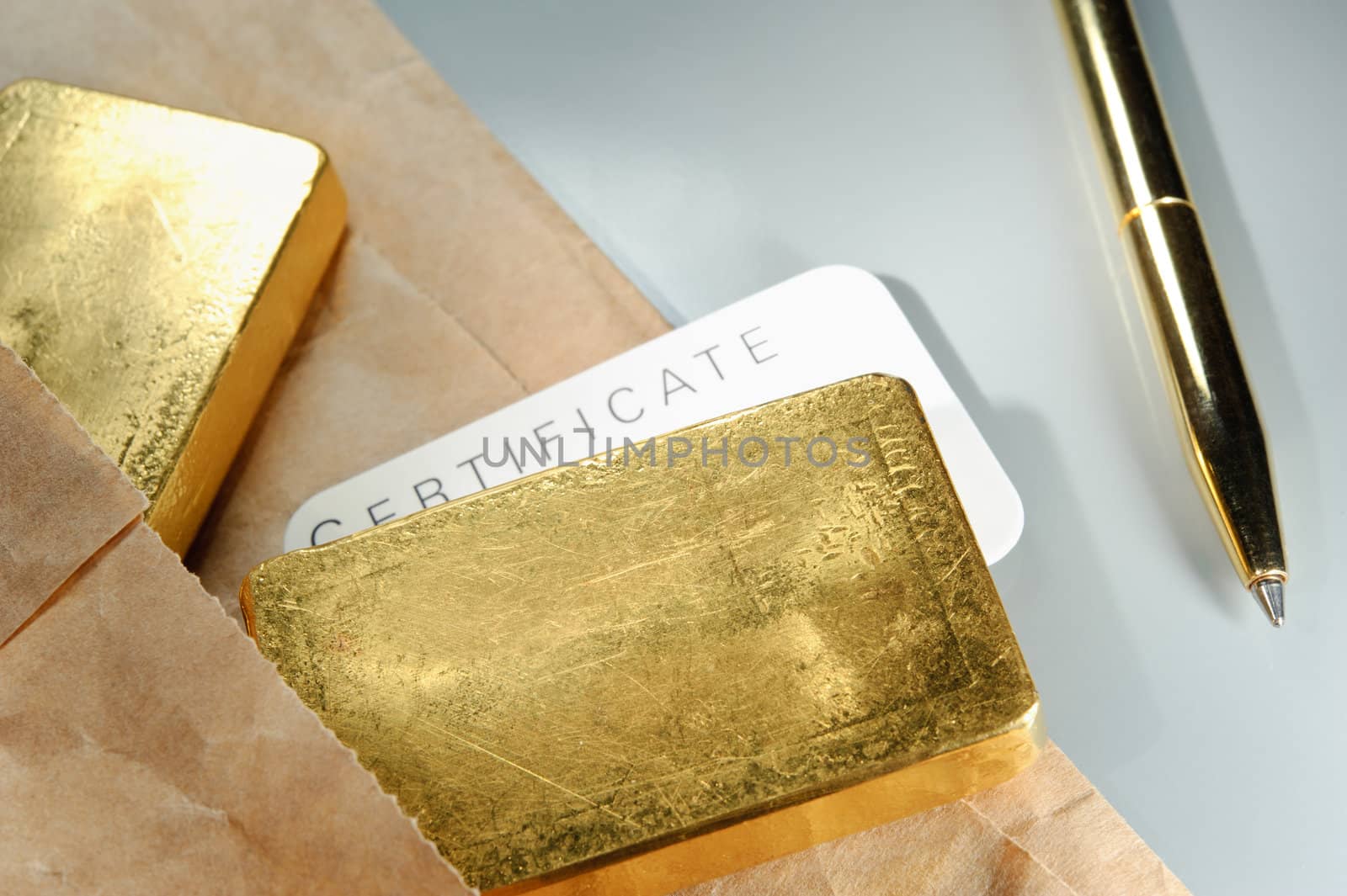 Processing and global trading of precious metals. Gold bars, certificate, pen and paper pack. Closeup.