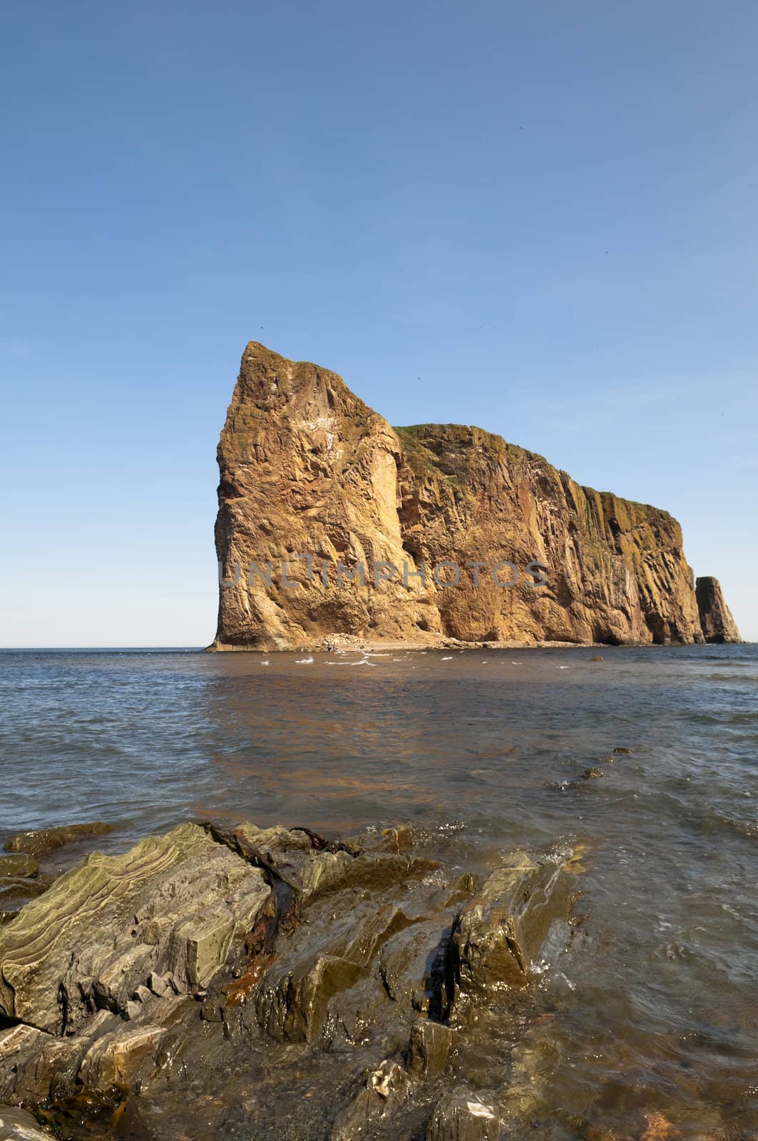 Perce Rock with copy space in the intense blue sky and rock formation in the foreground