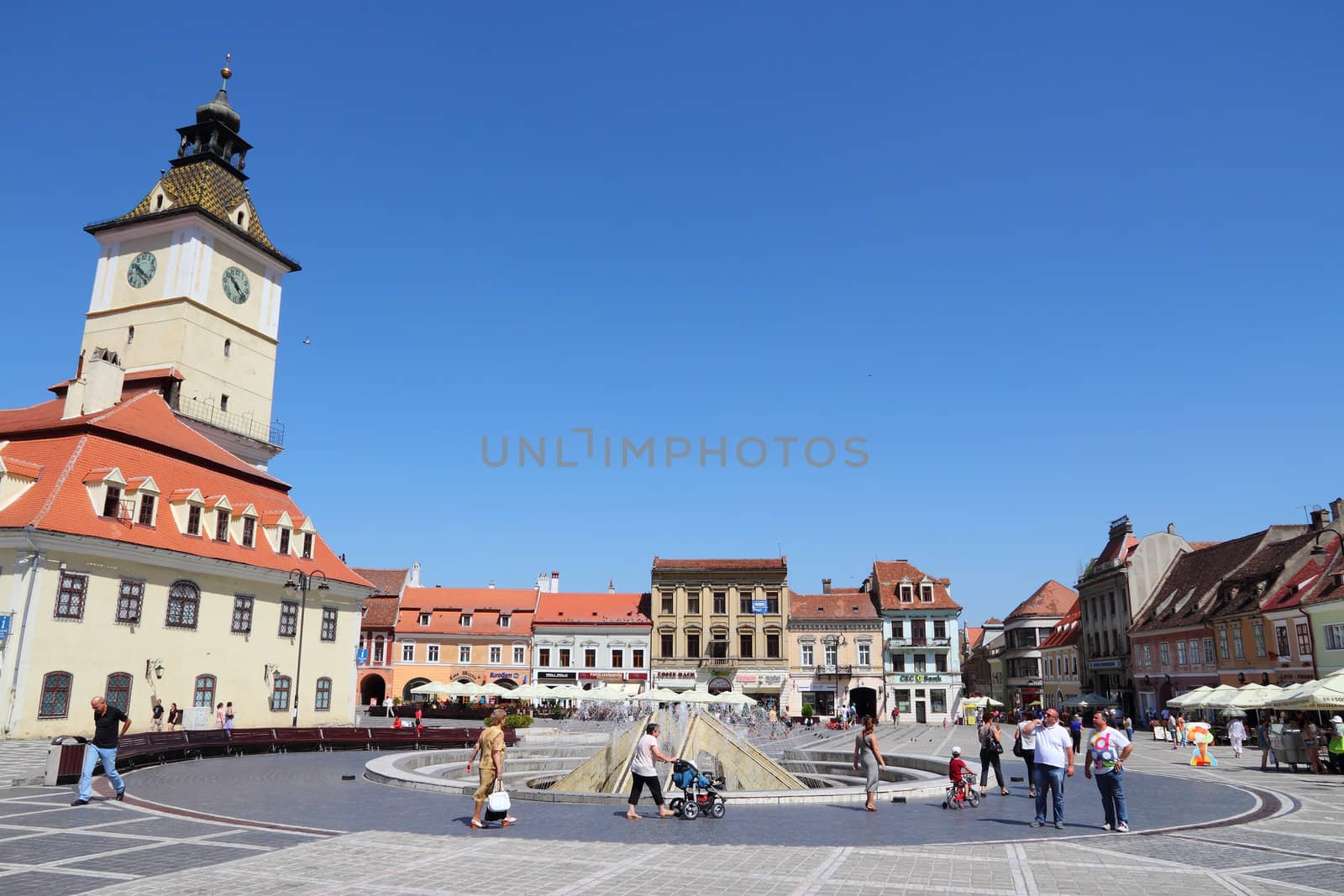 BRASOV, ROMANIA - AUGUST 21: Tourists stroll at main square on August 21, 2012 in Brasov, Romania. Brasov is a popular tourism destination with 581,983 arrivals in Brasov County in 2008.