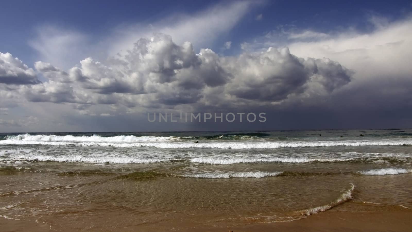 cumulus over the Mediterranean Sea and the waves incident on the beach