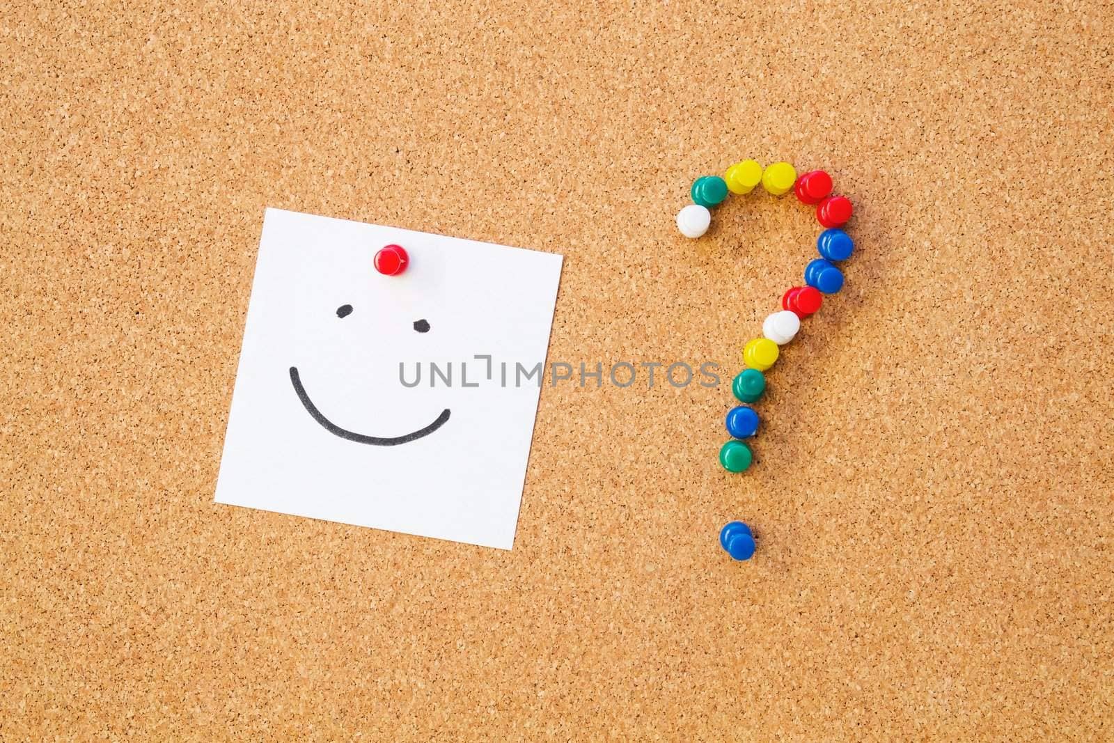 Smile note pinned to cord board. Question mark made of pushpins