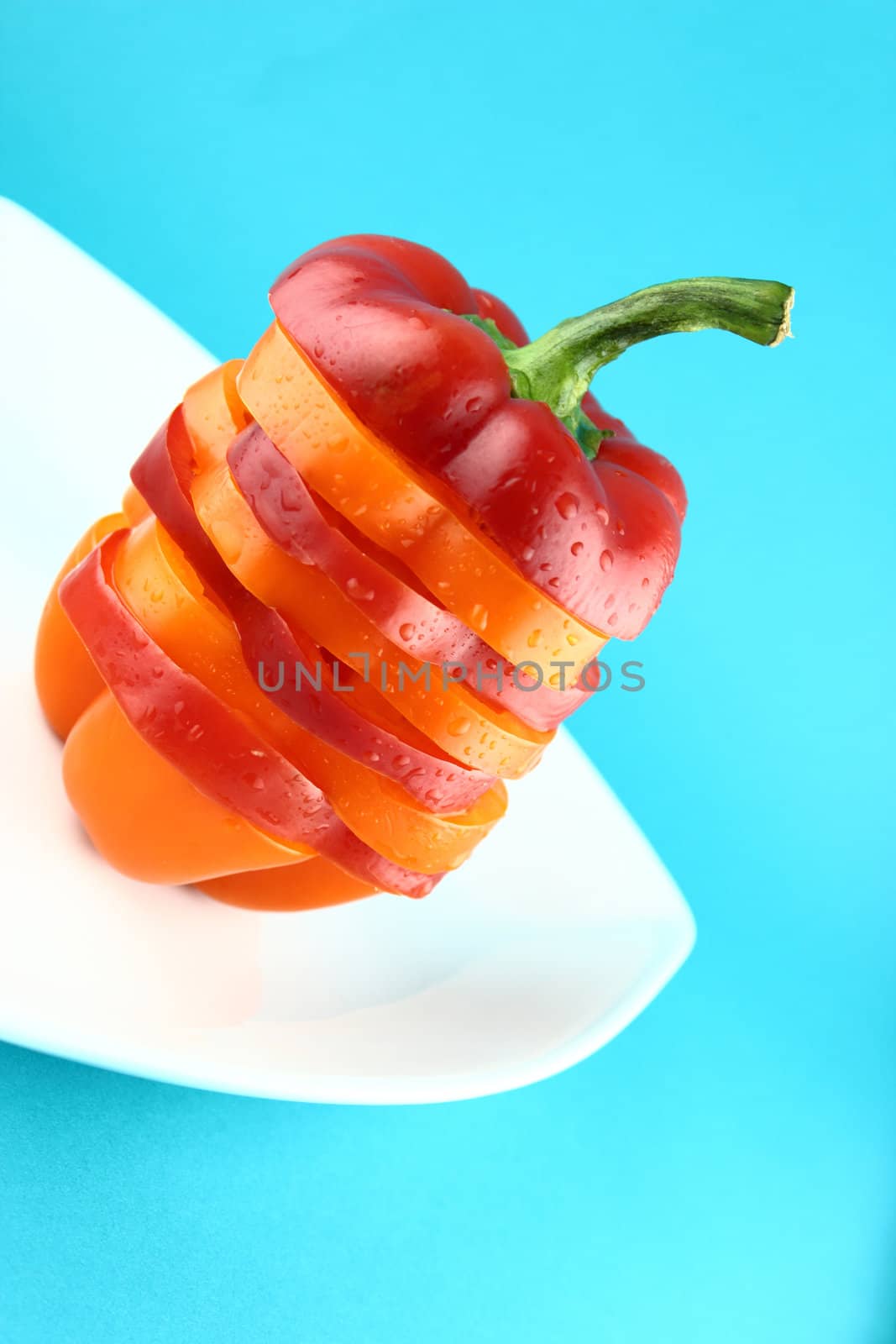 slices of colorful sweet bell pepper on blue background