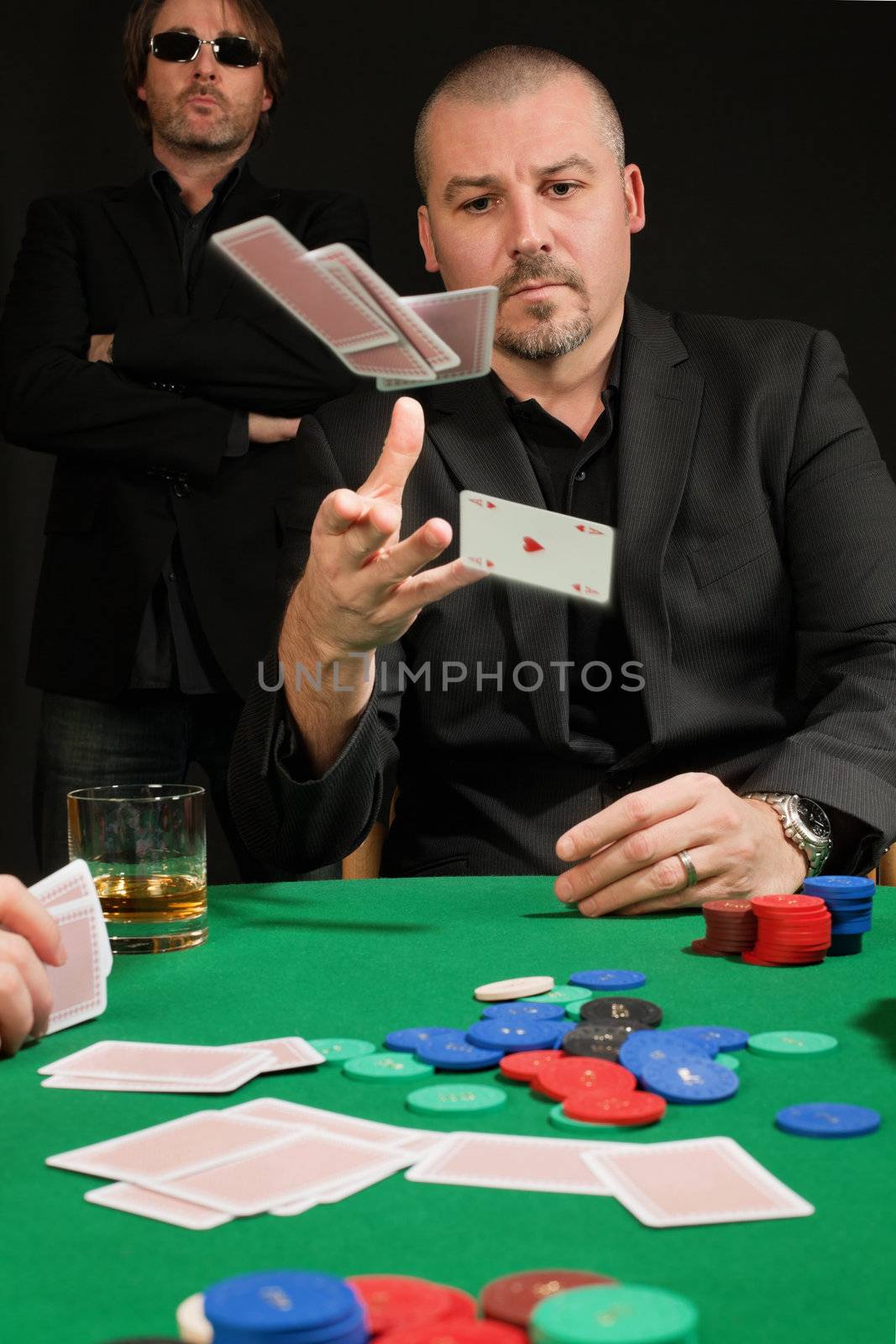 Photo of a poker player throwing in his cards.