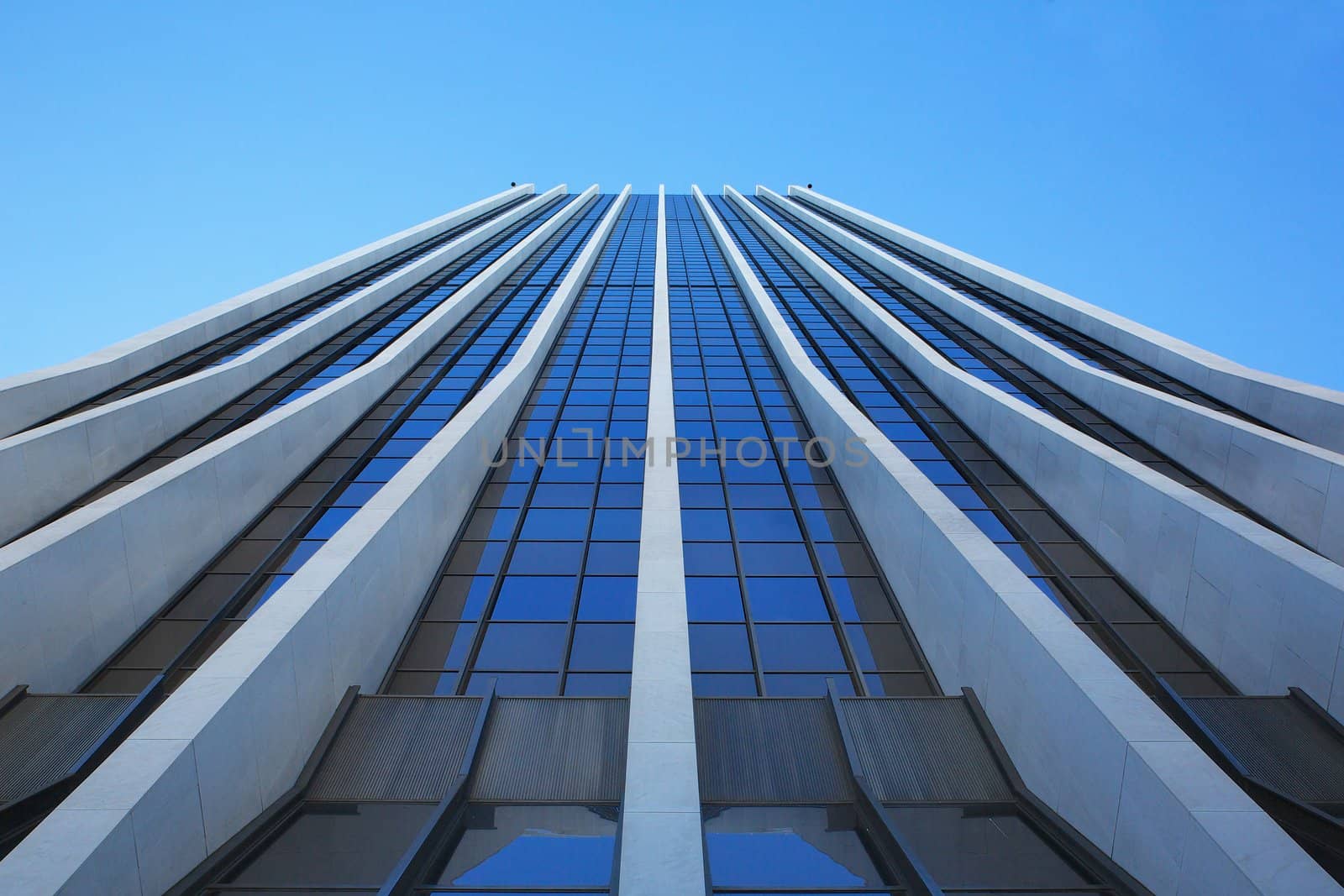 Close up vertical view of modern office building on a clear day that looks like a speed ramp to the sky