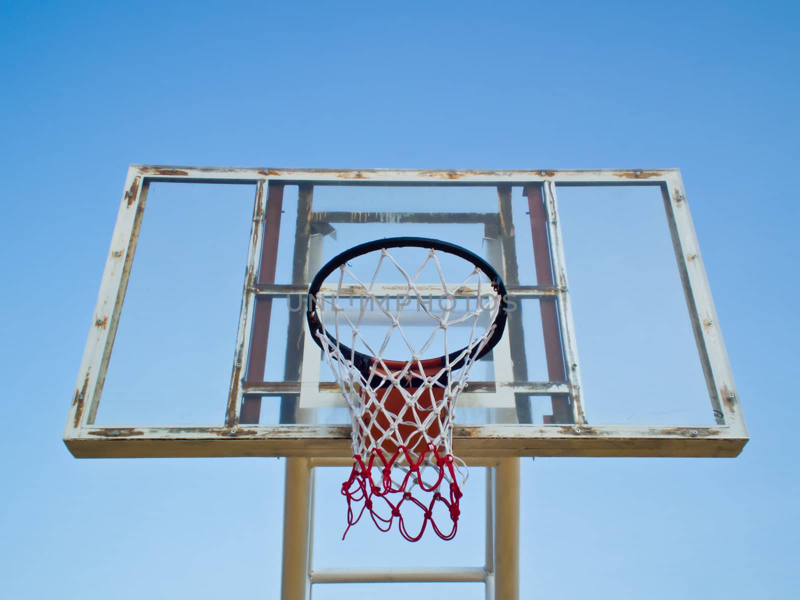 this is a old basketball hoop on blue sky background