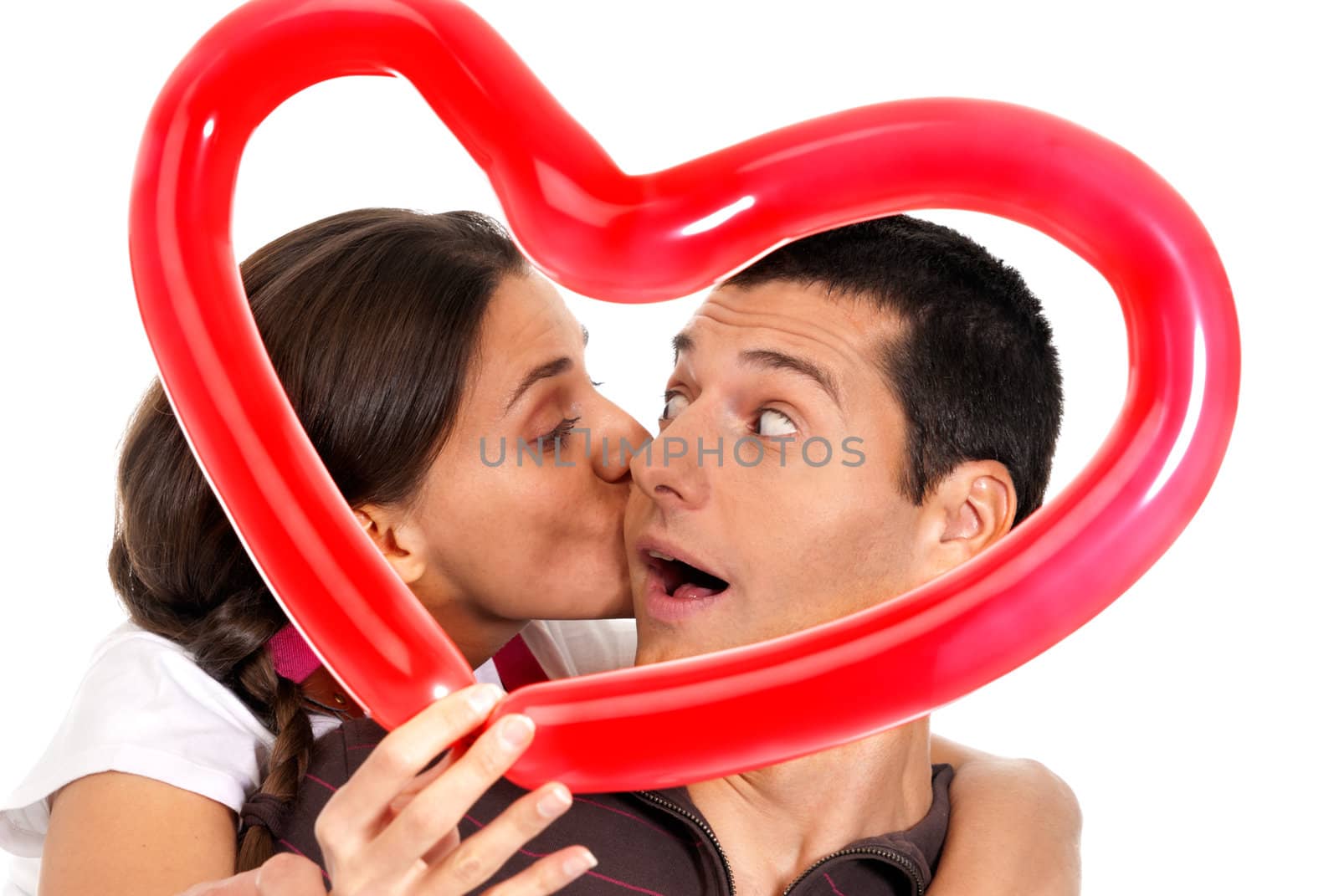 Young couple kissing through balloon heart surprise isolated on white background