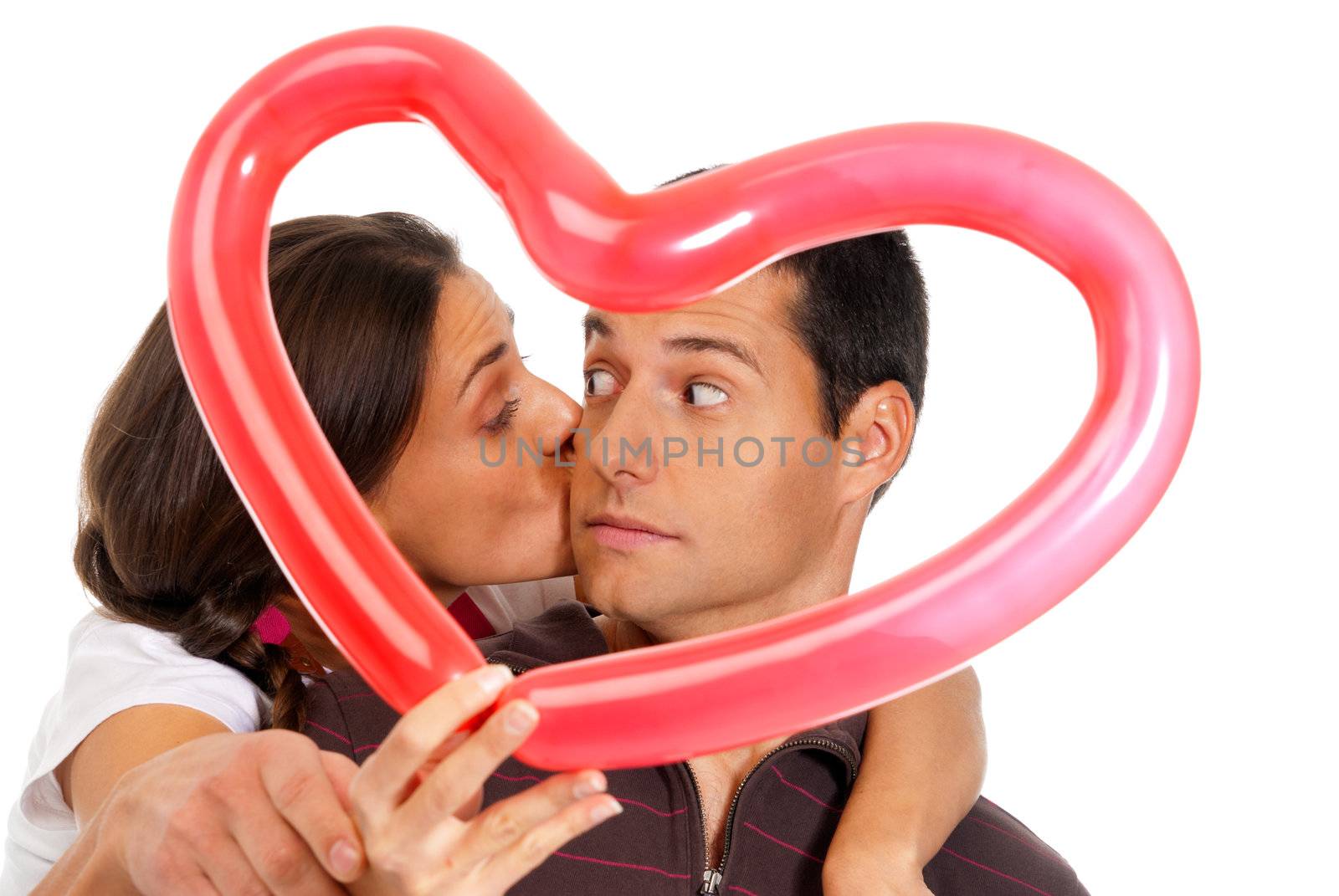 Young couple kissing through baloon heart surprise isolated on white background