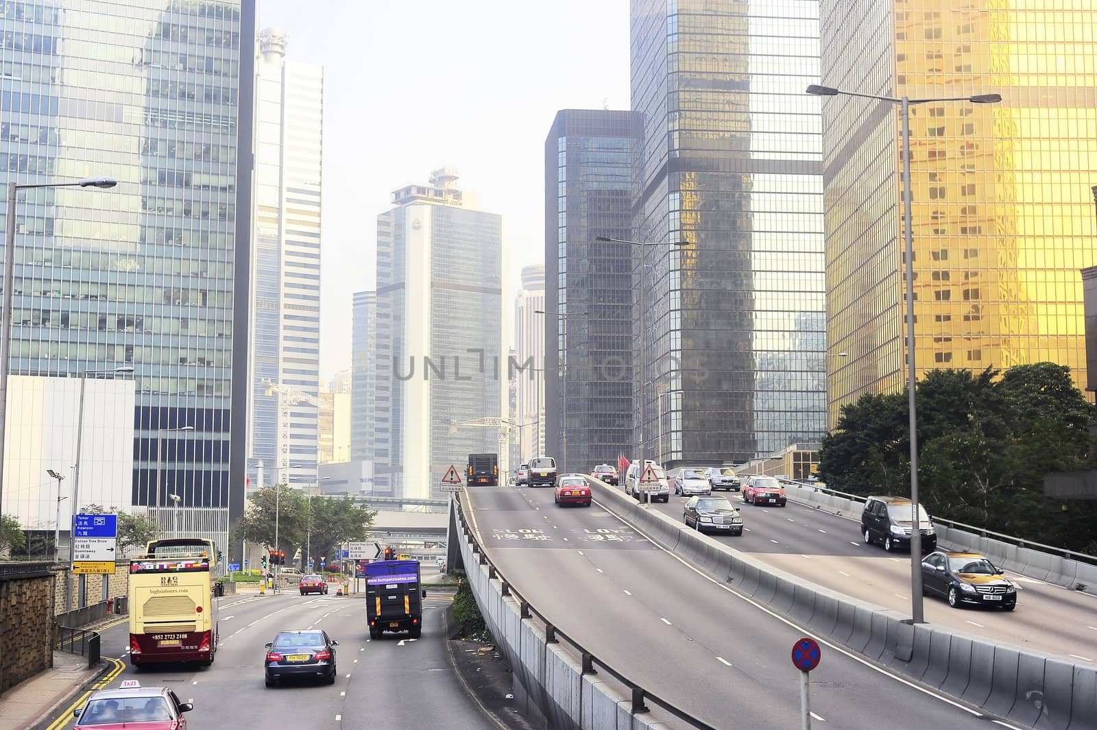 Hong Kong -  January 17, 2013: Many cars on the road at financial center of Hong Kong. Hong Kong is an international financial center, which consists of 112 buildings,standing higher than 180 meters