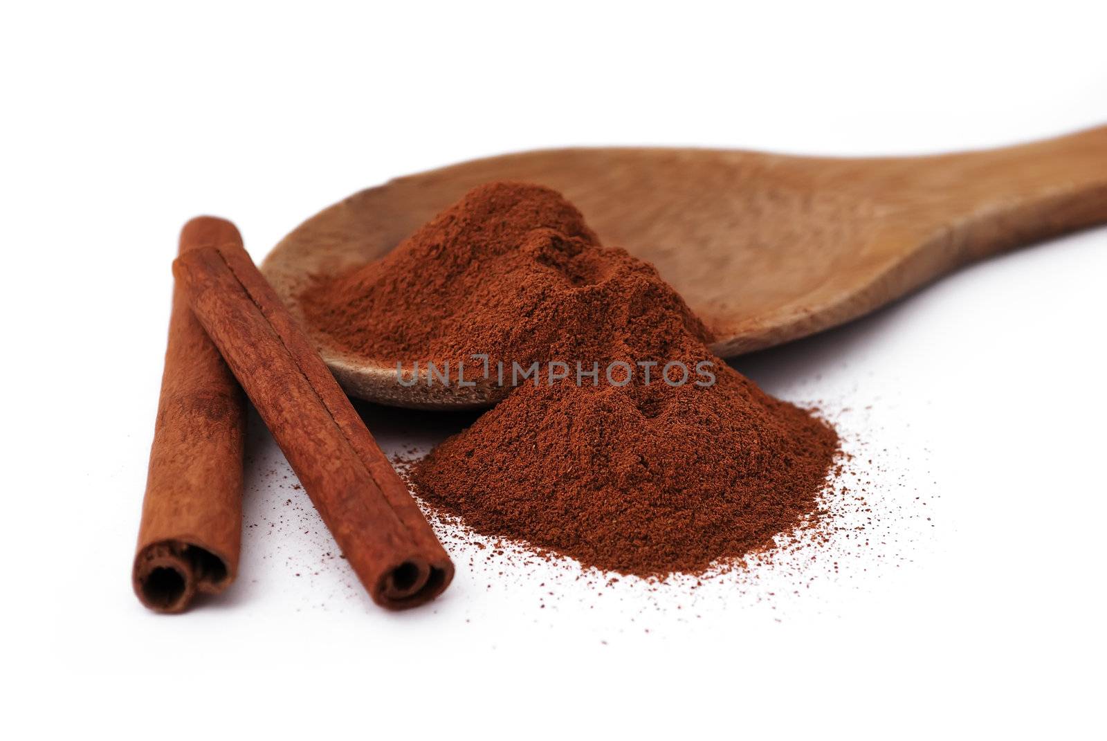 wooden spoon with cinnamon and a few tubes of cinnamon